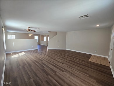 Unfurnished living room with dark wood-style floors and ceiling fan
