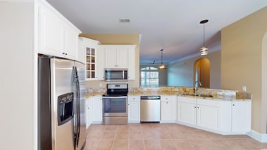 Kitchen featuring white cabinets, stainless steel 