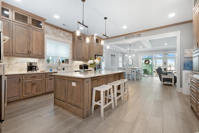 Kitchen featuring a center island, decorative backsplash, light wood-type flooring, a breakfast bar area, and glass insert cabinets