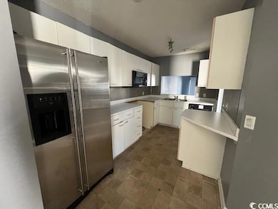 Kitchen with white cabinets, sink, and stainless s