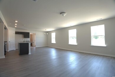 Unfurnished living room with a chandelier, dark wood-style floors, and recessed lighting