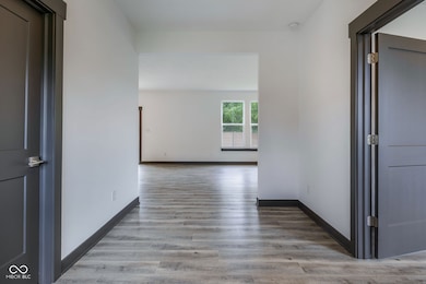 corridor with light LVP flooring and baseboards