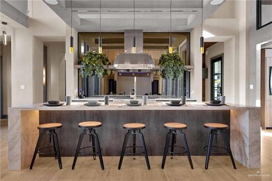 Kitchen with light wood-type flooring, a breakfast bar area, and hanging light fixtures