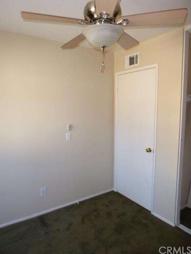 Bedroom showing ceiling fan and wall to wall carpe