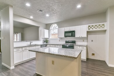 The cook of the family is certain to appreciate the roomy pantry to the right of the fridge space, as well as the appliances that include a single basin undermount sink, a black stainless dishwasher, and a gas cooktop & oven topped by a microwave with vent hood.