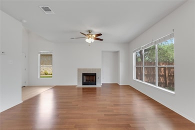 Unfurnished living room with ceiling fan, wood fi