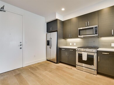 Kitchen featuring stainless steel appliances, lig