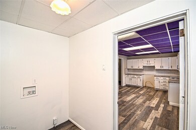 Laundry area with dark hardwood / wood-style flooring and washer hookup