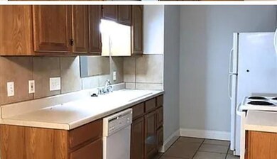 Kitchen with white appliances, brown cabinetry, l