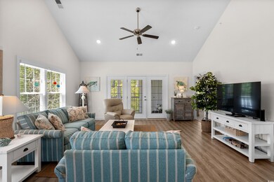 Living area featuring ceiling fan, high vaulted ce