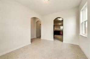 Spare room featuring arched walkways and lofted ce