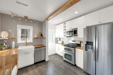 Kitchen featuring open shelves, appliances with stainless steel finishes, white cabinets, wooden counters, and recessed lighting