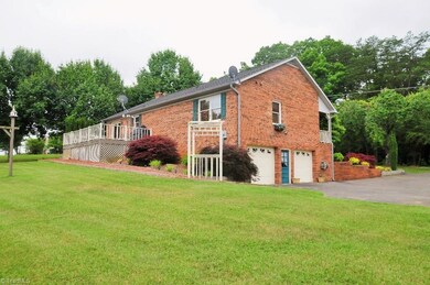Side and back view of brick ranch featuring an arbor, large deck off the kitchen and breakfast dining.