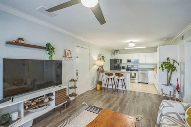 Living room with ornamental molding, light wood-s