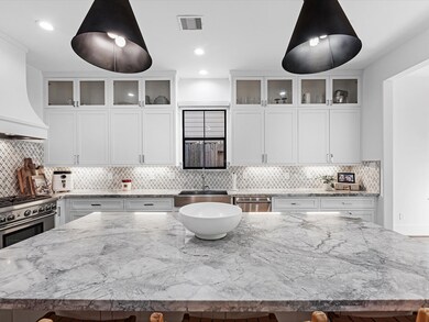 A modern kitchen with white cabinetry and herringb