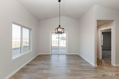 Unfurnished dining area with healthy amount of natural light, light wood-style flooring, lofted ceiling, and a chandelier