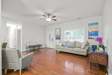 Living room with wood-type flooring and ceiling fa
