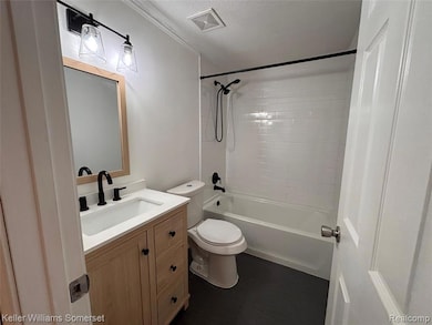 Bathroom featuring a textured ceiling, vanity, dark wood-type flooring, and tub / shower combination