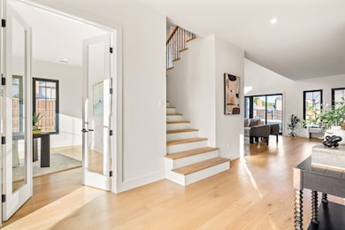 Stairway featuring wood finished floors, vaulted ceiling, and recessed lighting