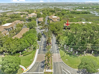 Aerial view of residential area featuring a large body of water and a tree filled landscape