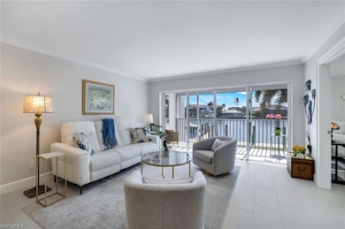 Living room featuring a water view, crown molding, and tile floors