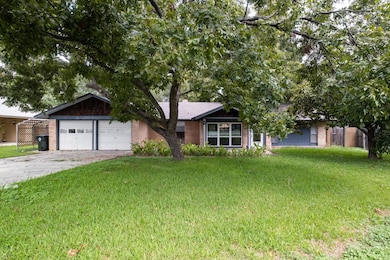 View of front facade with a front lawn, concrete driveway, brick siding, and an attached garage