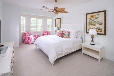 Bedroom with light colored carpet, a ceiling fan,