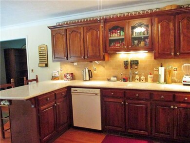 The dream kitchen boasts plenty of custom cabinetry, new solid surface counter space (2013), under the counter lighting, new hardwood (2013) and ceiling fan lighting. 