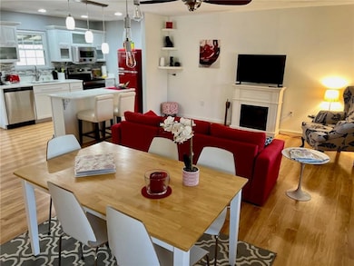 Dining room featuring ceiling fan, recessed lighting, a fireplace, and light wood-style flooring