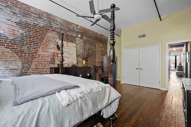 Bedroom with dark wood-type flooring, ceiling fan,