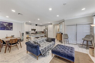 Living area featuring visible vents, crown molding