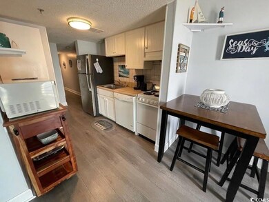 Kitchen featuring white appliances, custom range hood, light wood-style floors, tasteful backsplash, and open shelves