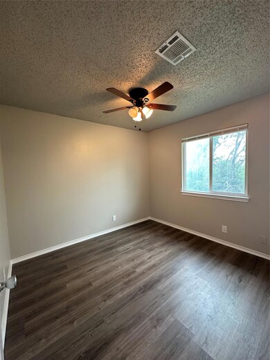 Spare room with ceiling fan, dark wood-style floo
