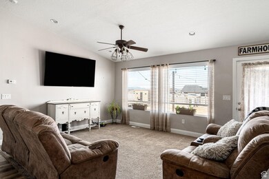 Living area with vaulted ceiling, carpet floors, ceiling fan, and recessed lighting