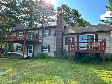 Rear view of house featuring a deck and a lawn