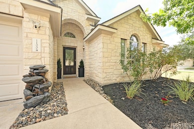 Property entrance featuring stone siding and a garage