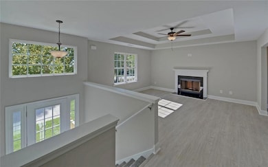 Unfurnished living room featuring baseboards, a ra