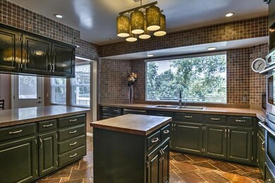 Updated designer kitchen with slate tile walls, gr