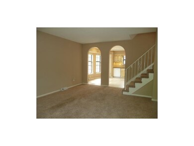 Neutral dcor and colors with arched doorways betwe