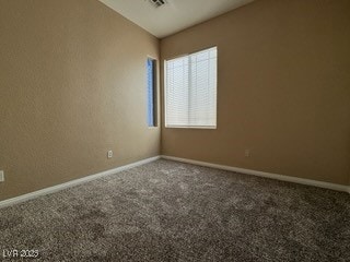Carpeted spare room with baseboards