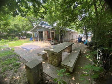 Back of property featuring a patio and an outbuil