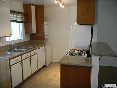 Galley kitchen with granite counters, tile floors,