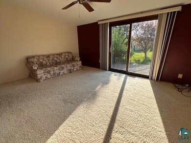 Sitting room featuring carpet and a ceiling fan