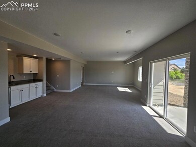 Unfurnished living room featuring carpet and sink