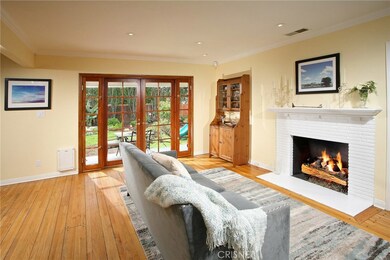 The family room is bathed in natural light from a multitude of windows and is further accented by modern recessed lighting, elegant crown molding, a raised hearth brick fireplace with mantle, wood-framed French doors with side-lights that open and co