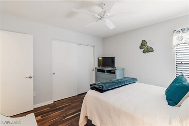Bedroom with ceiling fan, dark hardwood / wood-sty