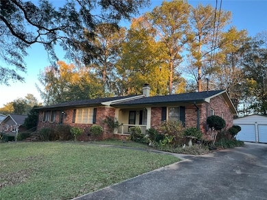 Single story home featuring an outbuilding, a garage, and a front lawn