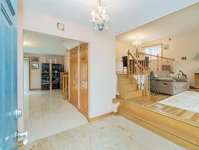 Entry foyer featuring a chandelier, stairway, and light tile patterned flooring