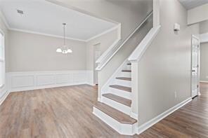 Staircase featuring ornamental molding and wood fi