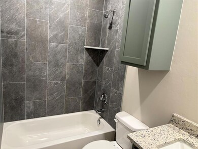 Full bath featuring tub / shower combination, vanity, and toilet